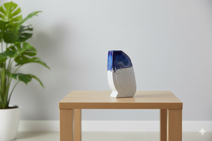 Vase with blue and white design on a wooden table next to a plant
