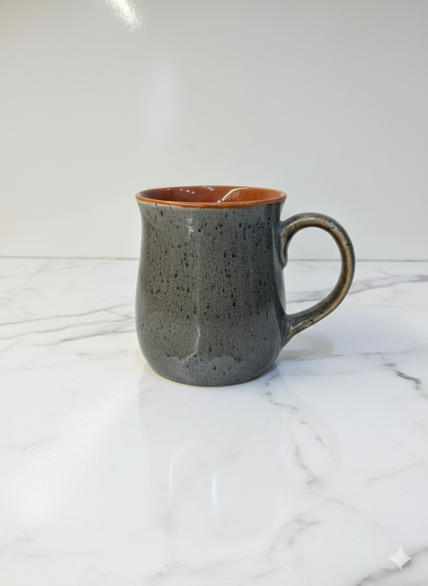 Gray speckled ceramic mug on a white marble surface