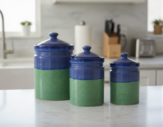 Three ceramic canisters with blue lids on a kitchen counter