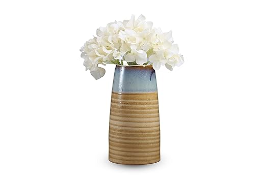 A ceramic flower vase with cream and mustard colors, featuring a glossy finish and a bouquet of white flowers placed in it.