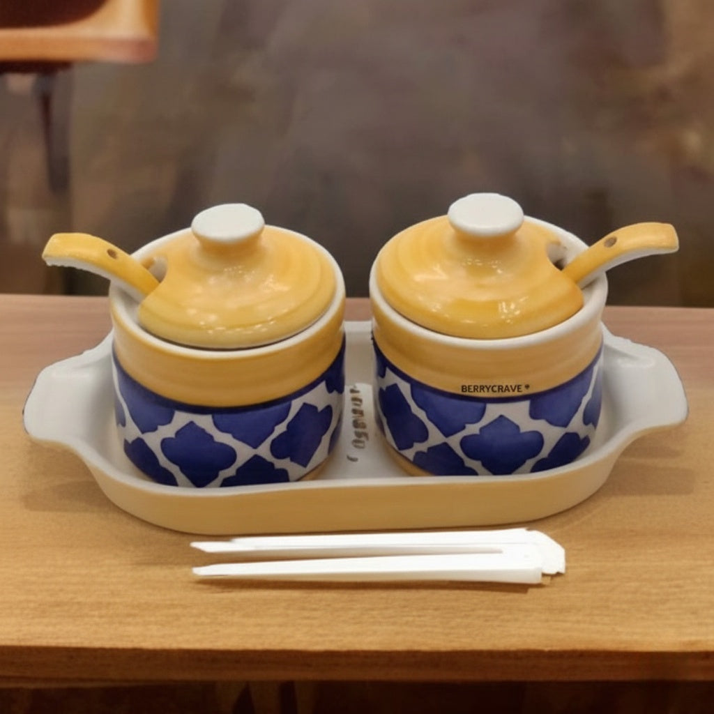 Two ceramic pots with blue patterns on a white tray, accompanied by chopsticks on a wooden surface.