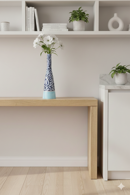 Modern interior with a wooden desk, decorative vase, and plants.