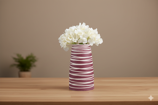 Striped vase with white flowers on a wooden table against a beige wall
