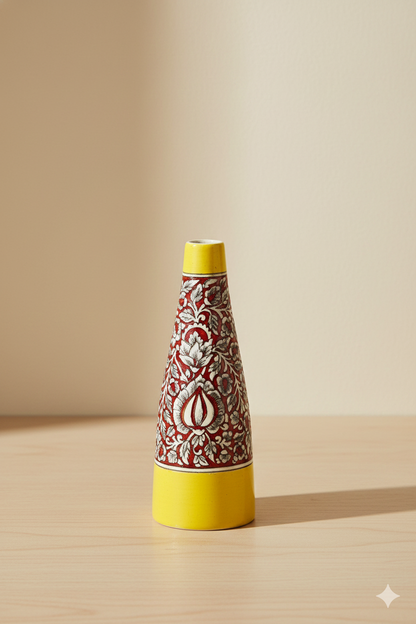 Decorative bottle with yellow top and red and white patterned body on a beige background